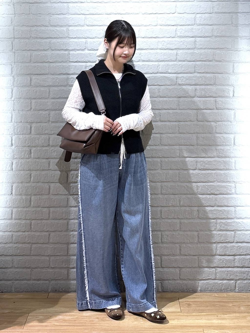 ブラウン系のバレエシューズ、ホワイト系のTシャツ/カットソー、ブラック系のベストを着用したレディースの秋コーディネートの2枚目の写真