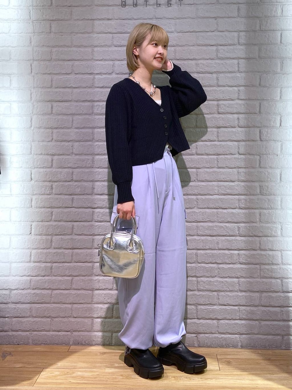 ホワイト系のタンクトップ、ブラック系のブーツ、ブラック系のカーディガン/ボレロを着用したレディースの秋コーディネートの2枚目の写真