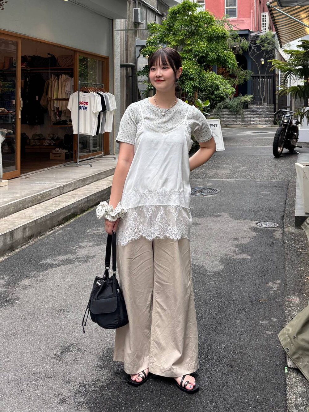 ベージュ系のデニムパンツ、ブラック系のサンダル、ホワイト系のTシャツ/カットソーを着用したレディースの夏コーディネートの2枚目の写真