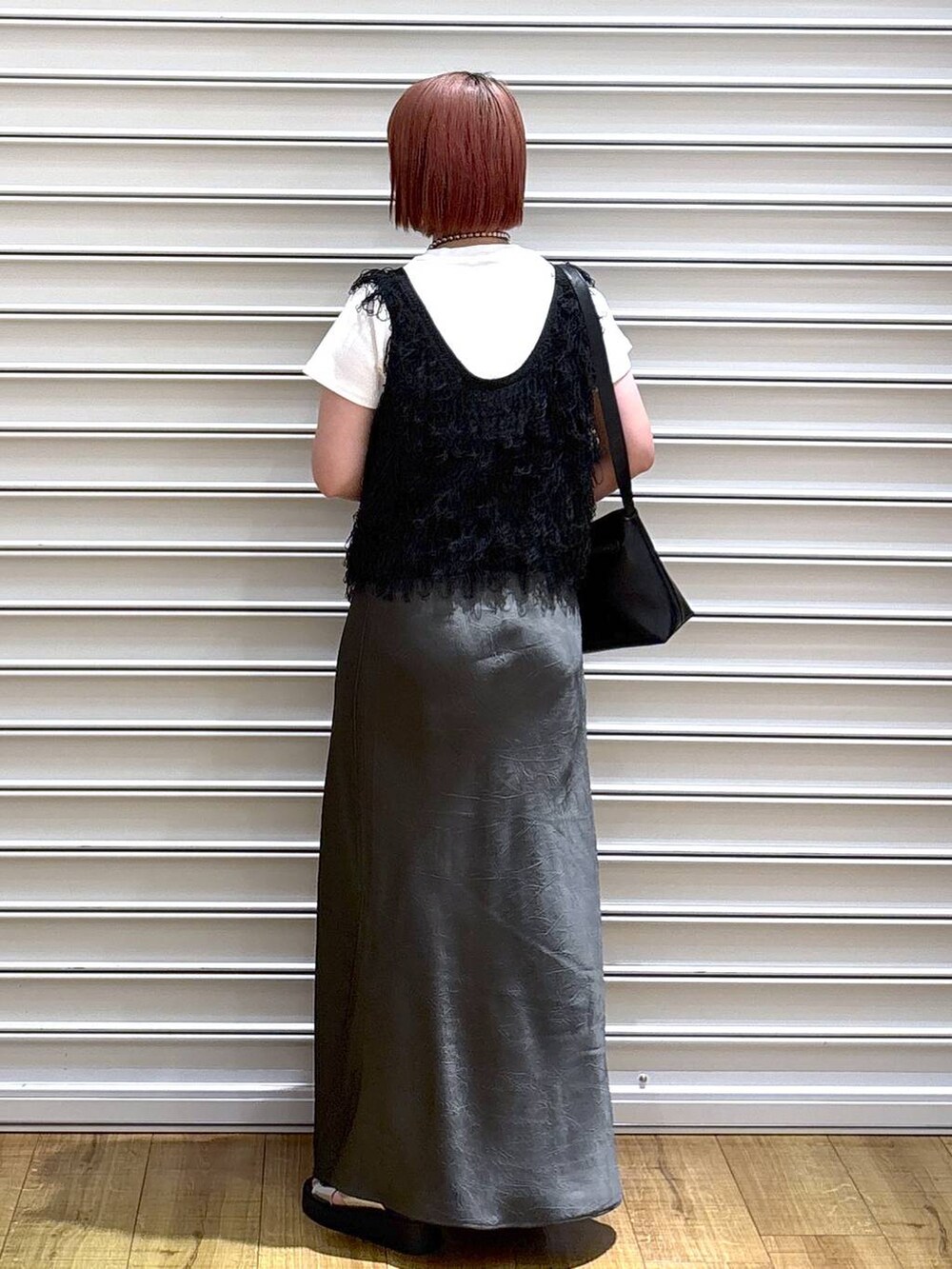 シルバー系のサンダル、グレー系のスカート、ブラック系のショルダーバッグを着用したレディースの夏コーディネートの3枚目の写真