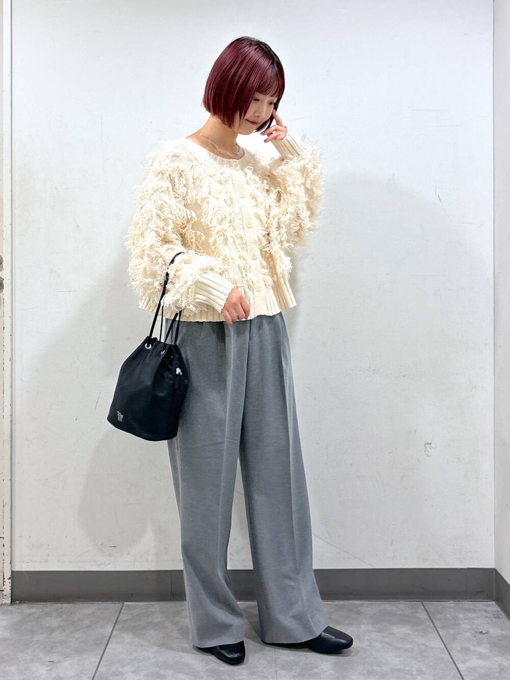 ブラック系のブーツ、グレー系のその他パンツ、ブラック系のハンドバッグを着用したレディースの秋コーディネートの2枚目の写真