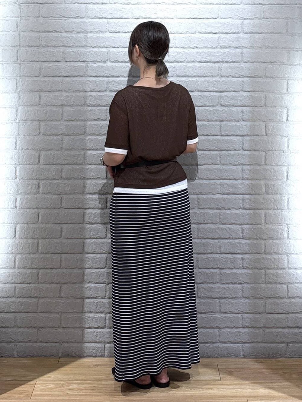 ブラック系のサンダル、ブラウン系のTシャツ/カットソー、ブラック系のスカートを着用したレディースの夏コーディネートの3枚目の写真