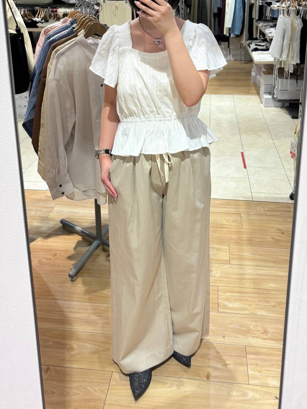 ベージュ系のデニムパンツ、ブラック系のパンプス、ホワイト系のシャツ/ブラウスを着用したレディースの春コーディネートの3枚目の写真
