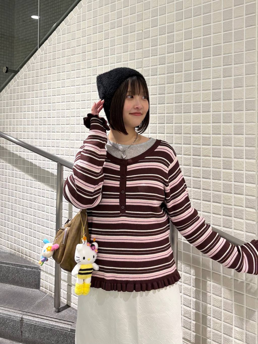 ホワイト系のスカート、ブラック系のブーツ、ブラウン系のニット/セーターを着用したレディースの冬コーディネートの2枚目の写真