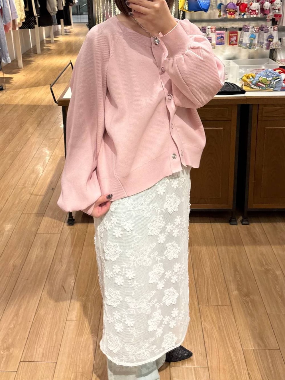 ブルー系のデニムパンツ、ブラック系のパンプス、ホワイト系のスカートを着用したレディースの冬コーディネートの2枚目の写真