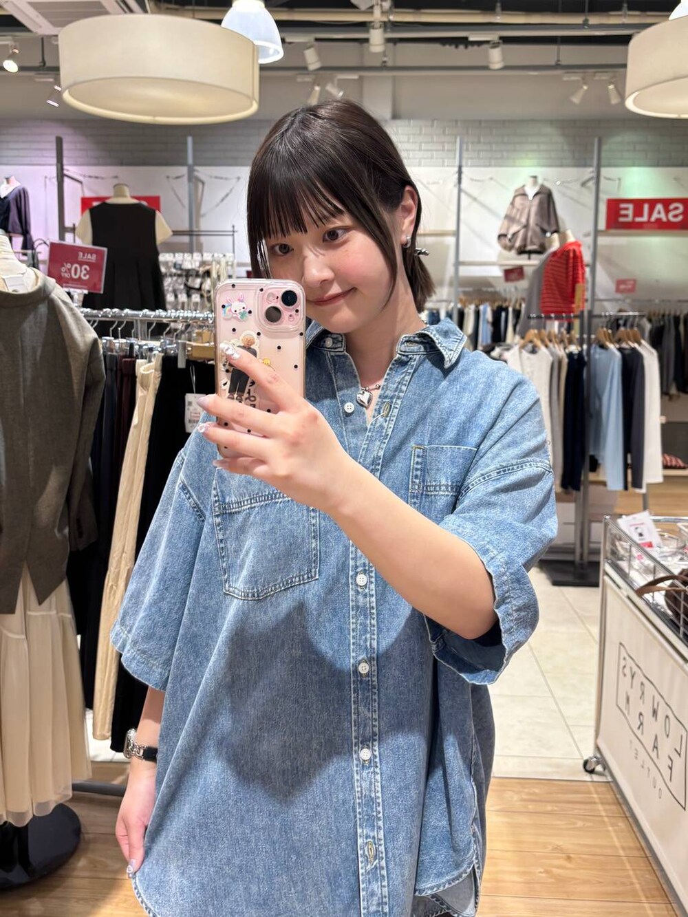 ブラック系のスカート、ブラウン系のサンダル、ブルー系のシャツ/ブラウスを着用したレディースの春コーディネートの2枚目の写真