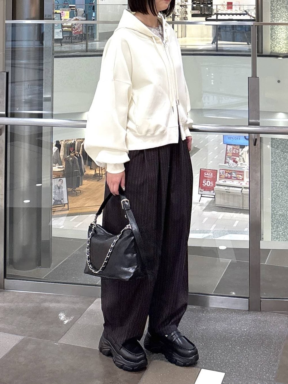 ブラウン系のその他パンツ、ベージュ系のパーカー、ブラック系のショルダーバッグを着用したレディースの冬コーディネートの2枚目の写真