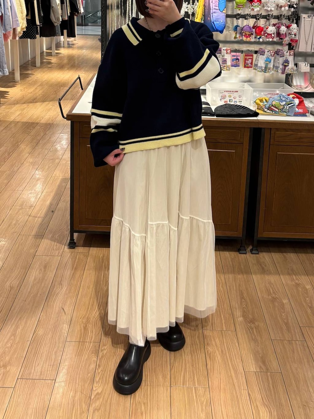 ブラック系のサンダル、ホワイト系のスカート、ブルー系のニット/セーターを着用したレディースの冬コーディネートの3枚目の写真