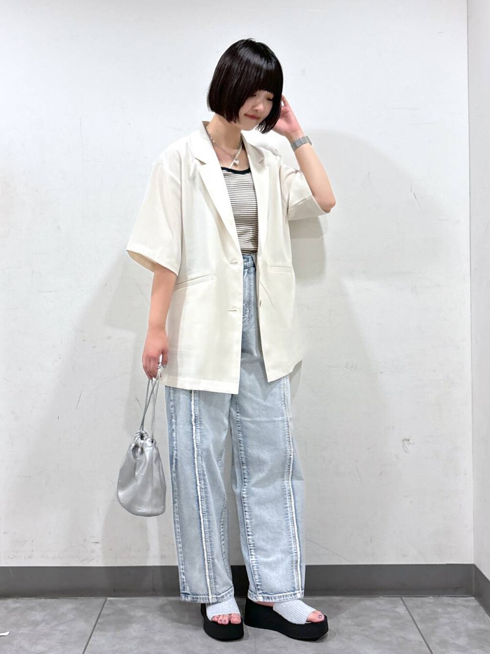 シルバー系のサンダル、ホワイト系のショルダーバッグ、ブラック系のタンクトップを着用したレディースの夏コーディネートの2枚目の写真