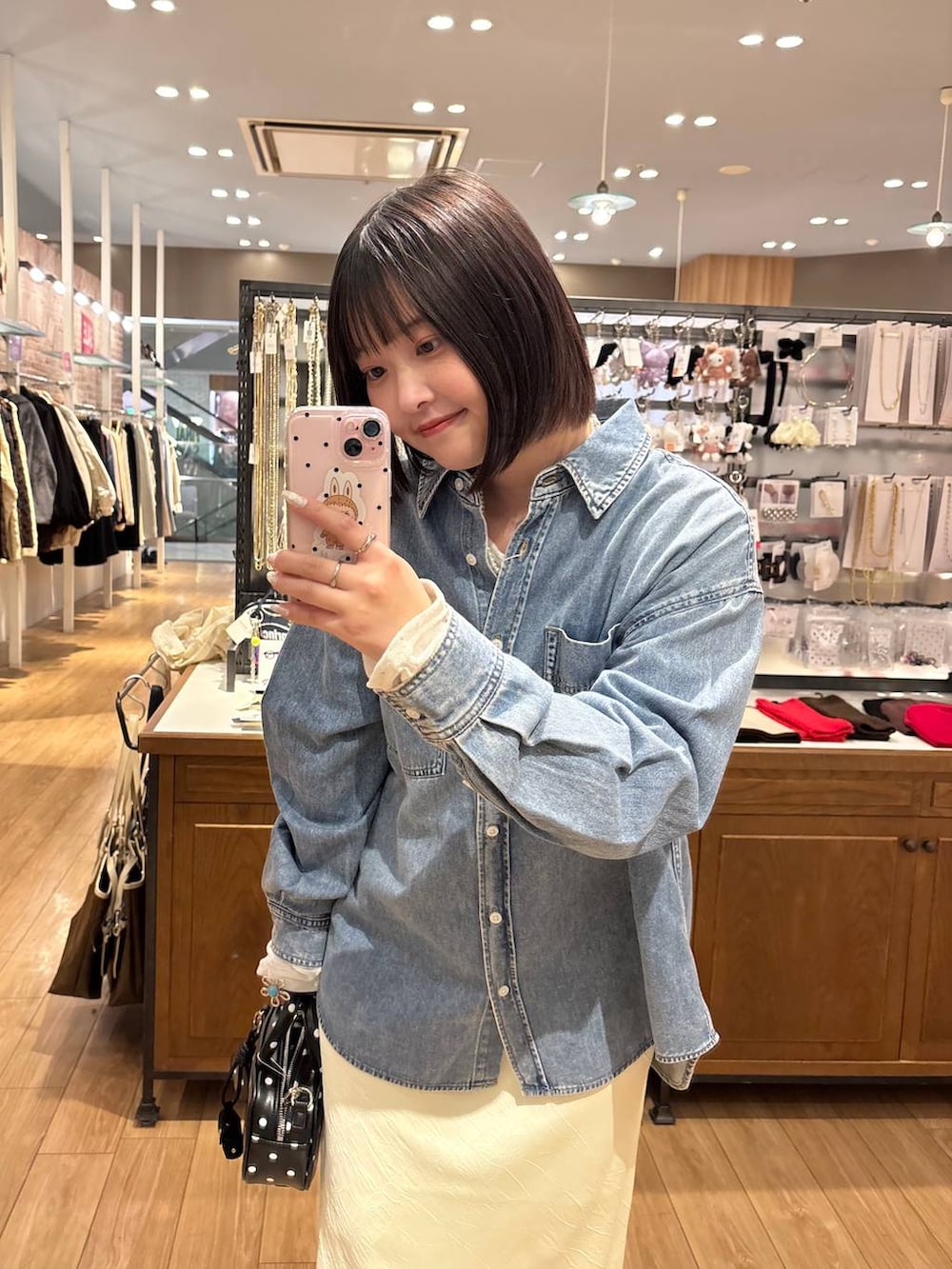 イエロー系のスカート、その他のボストンバッグ、ブルー系のシャツ/ブラウスを着用したレディースの冬コーディネートの2枚目の写真