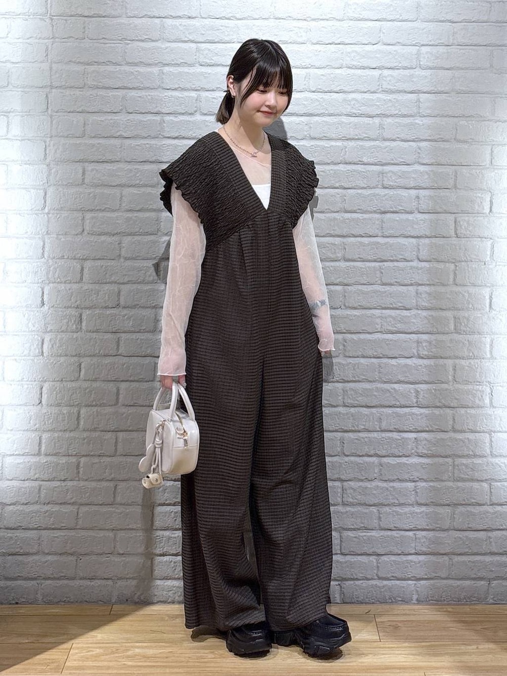 ブラウン系のサロペット/オーバーオール、ホワイト系のボストンバッグ、ブラック系のローファーを着用したレディースの春コーディネートの2枚目の写真