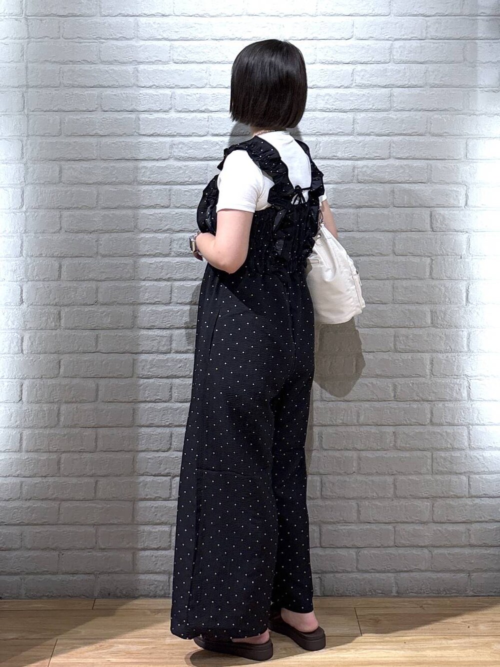 ホワイト系のTシャツ/カットソー、ブラウン系のサンダル、ホワイト系のショルダーバッグを着用したレディースの夏コーディネートの3枚目の写真