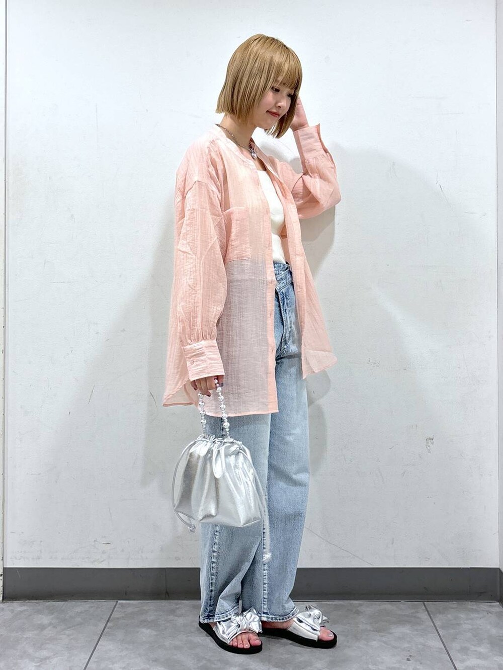 シルバー系のサンダル、ホワイト系のタンクトップ、シルバー系のショルダーバッグを着用したレディースの夏コーディネートの2枚目の写真