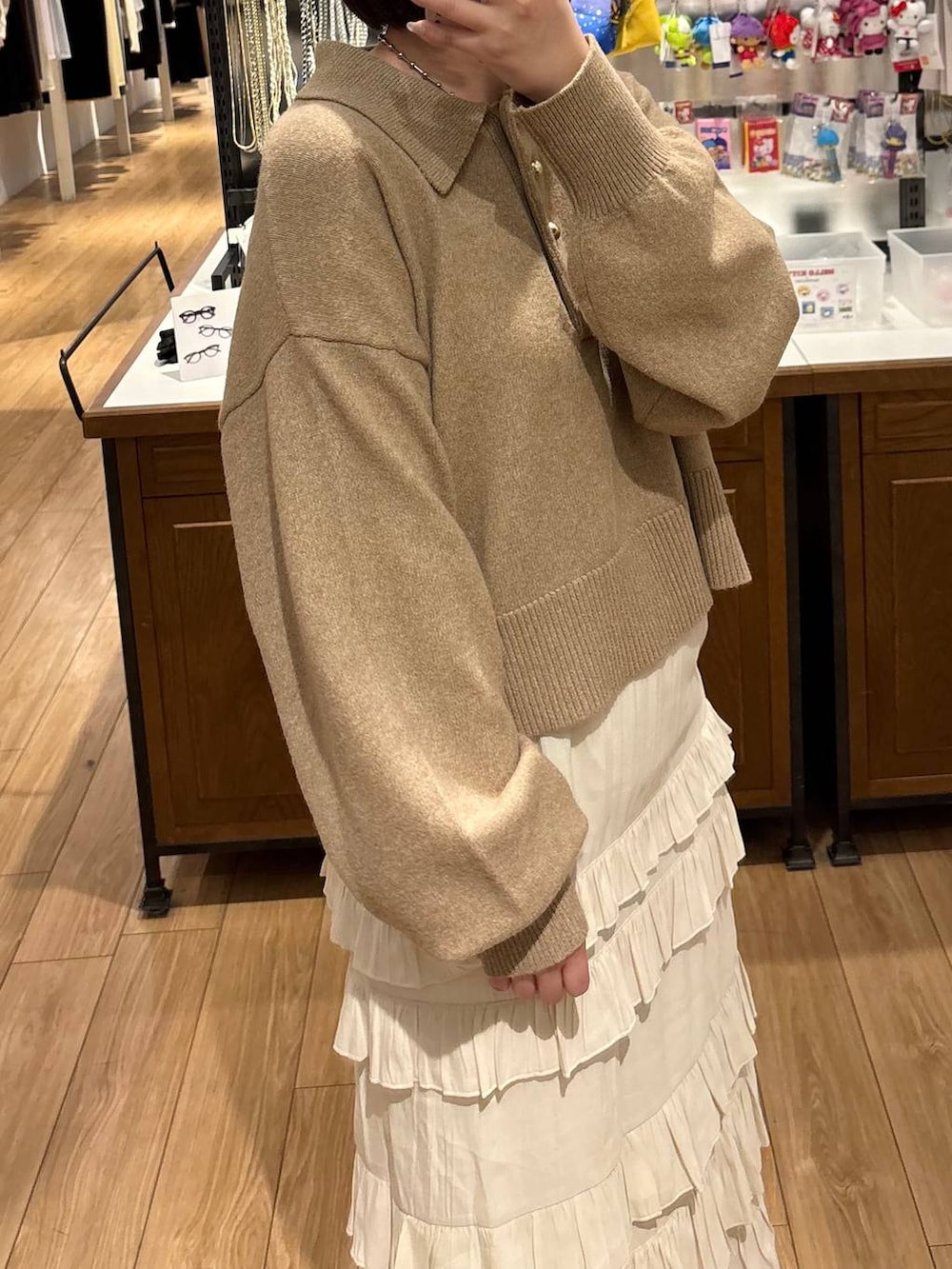 ブラック系のローファー、ホワイト系のスカート、ブラウン系のニット/セーターを着用したレディースの冬コーディネートの2枚目の写真