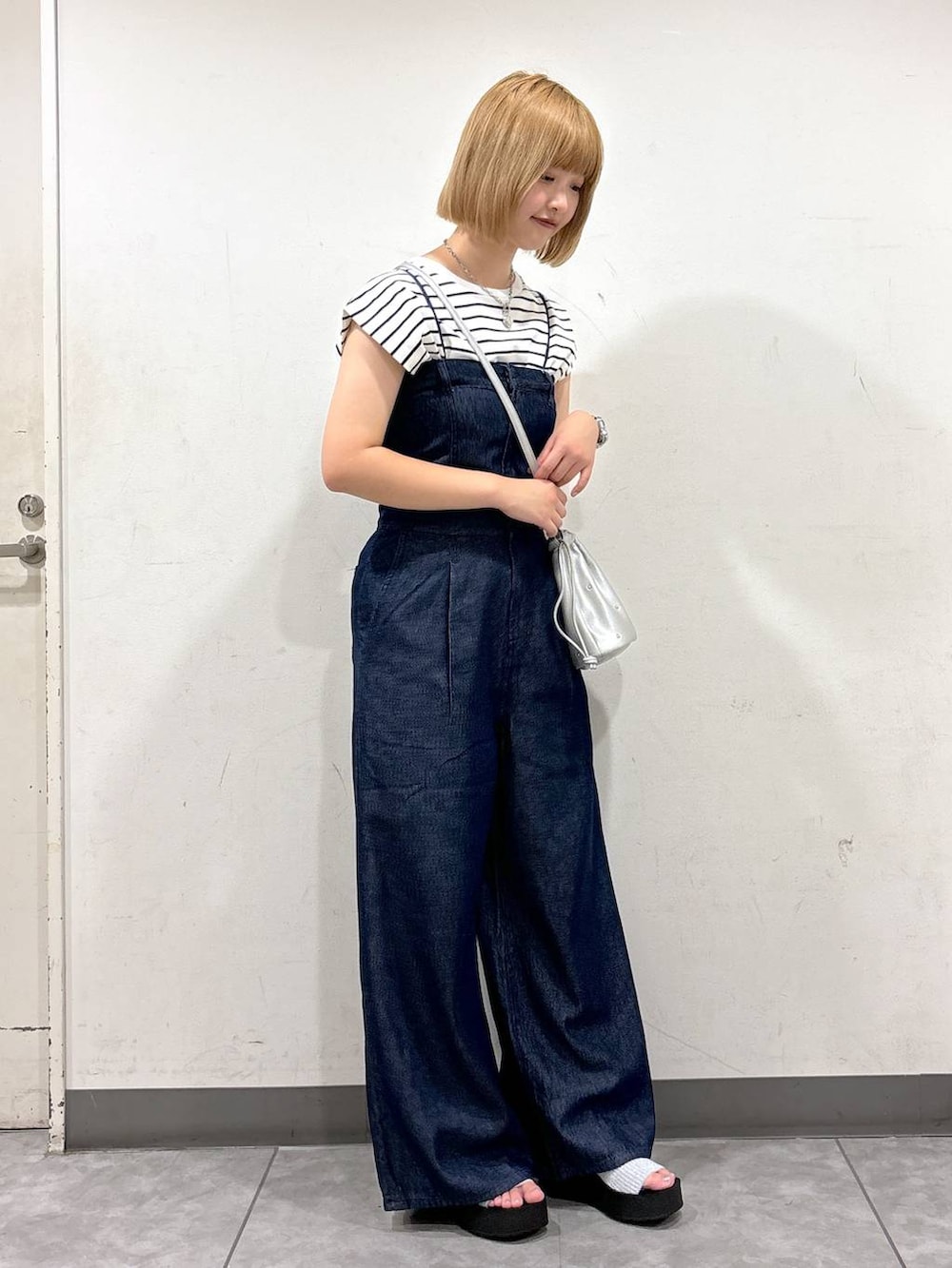 シルバー系のサンダル、シルバー系のショルダーバッグ、ブラック系のTシャツ/カットソーを着用したレディースの夏コーディネートの2枚目の写真