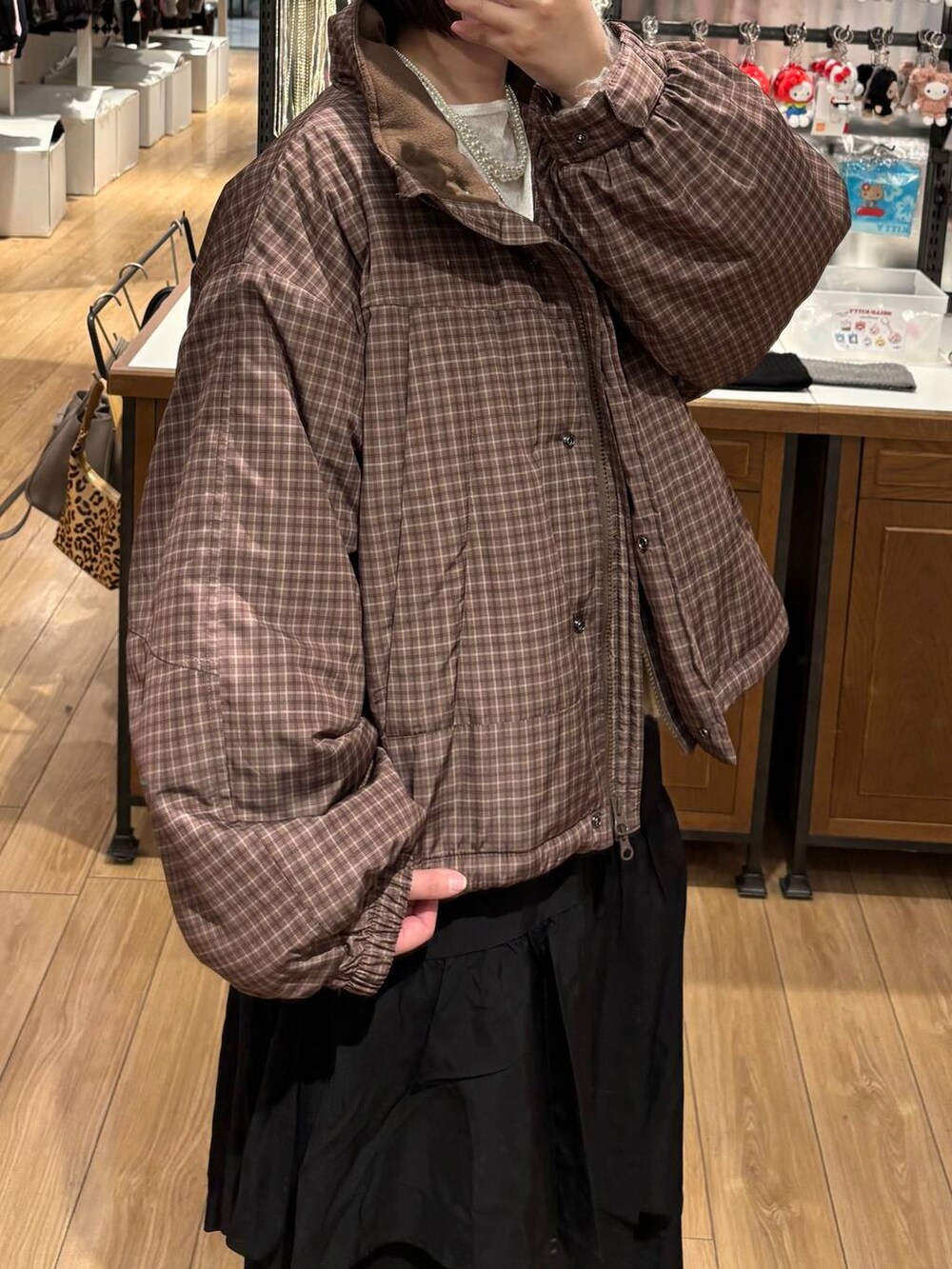 ブラック系のブーツ、ブラック系のスカート、ブラウン系のブルゾンを着用したレディースの冬コーディネートの2枚目の写真