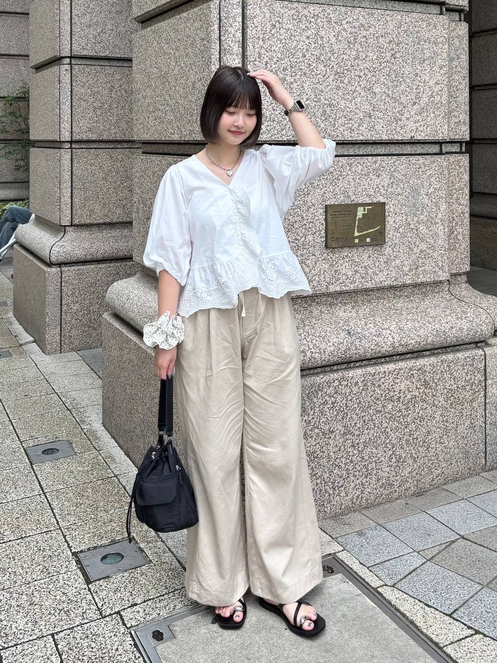 ベージュ系のデニムパンツ、ブラック系のサンダル、ホワイト系のシャツ/ブラウスを着用したレディースの夏コーディネートの3枚目の写真