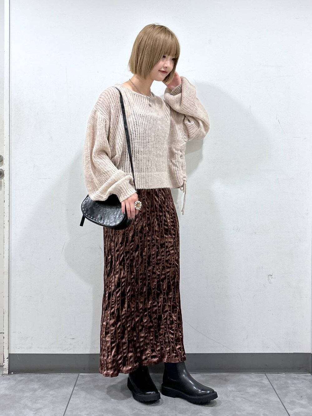 ブラック系のショルダーバッグ、ブラウン系のワンピース、ホワイト系のニット/セーターを着用したレディースの秋コーディネートの2枚目の写真