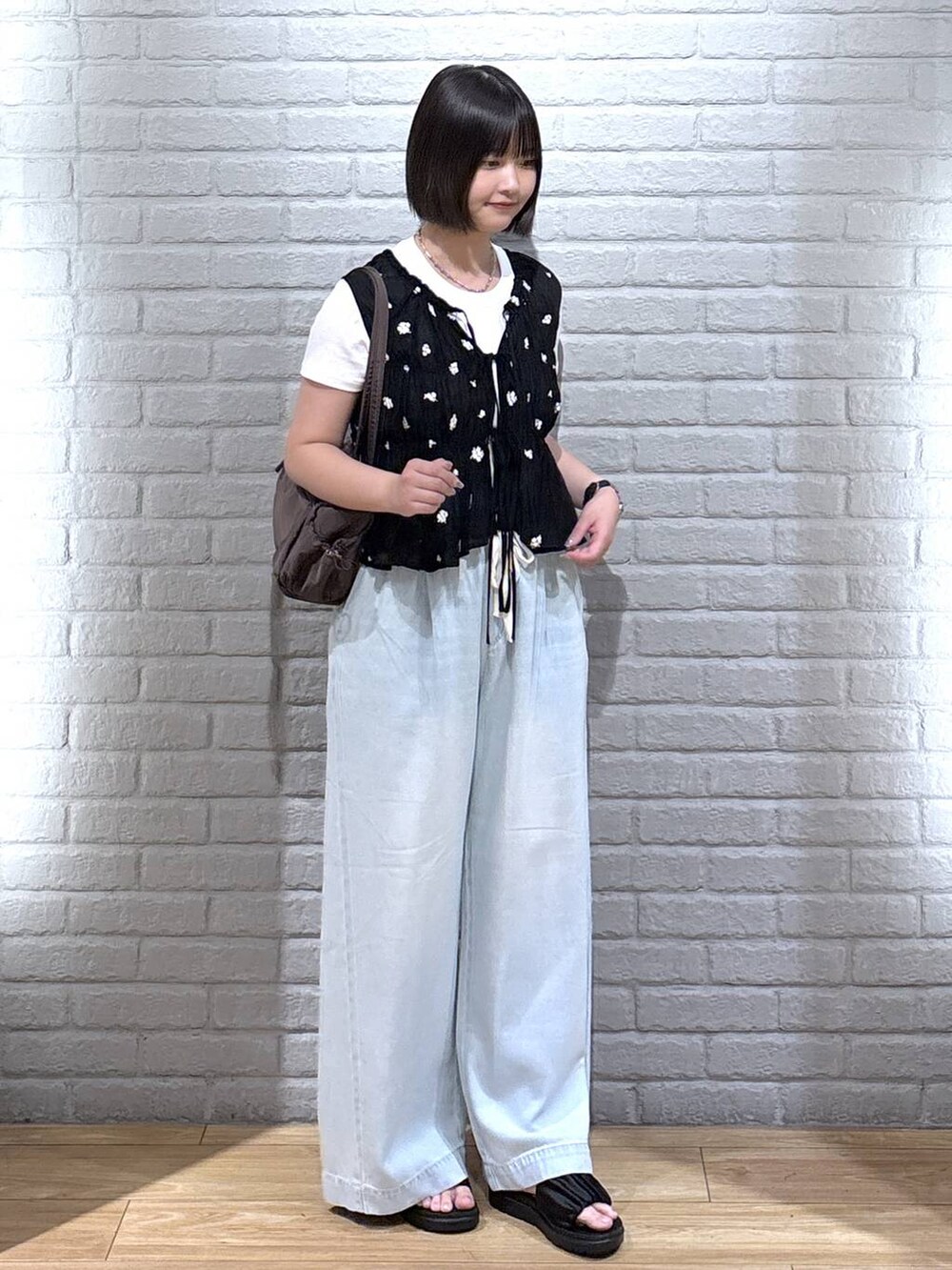 ホワイト系のTシャツ/カットソー、ブルー系のデニムパンツ、ブラウン系のサンダルを着用したレディースの夏コーディネートの2枚目の写真