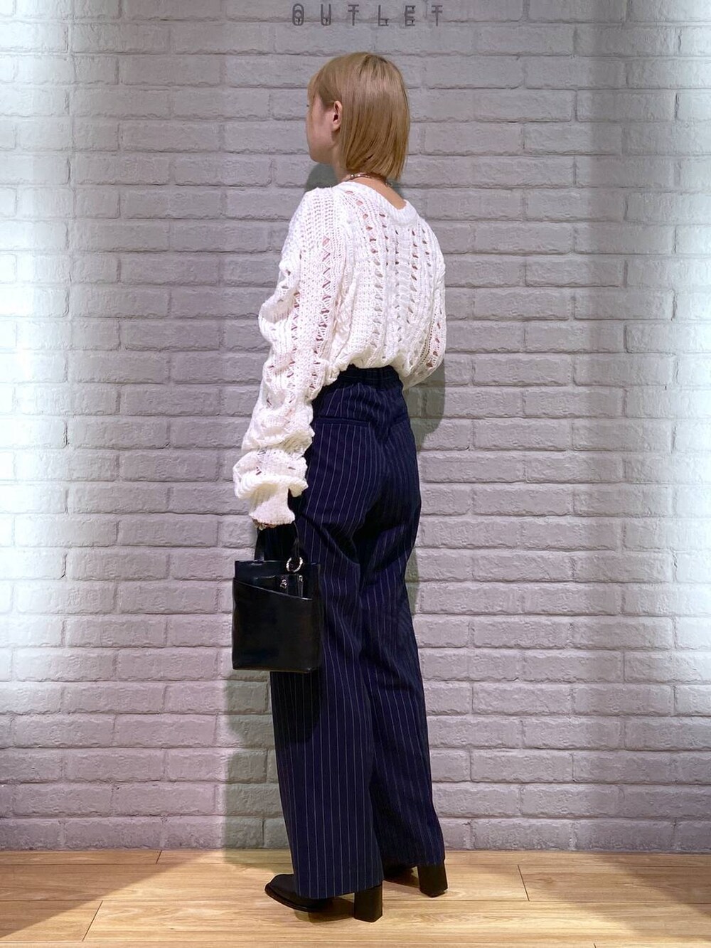 ブルー系のその他パンツ、ブラック系のパンプス、ブラック系のショルダーバッグを着用したレディースの秋コーディネートの3枚目の写真