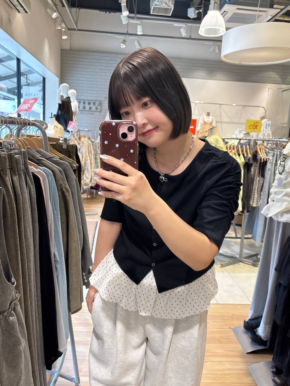 グレー系のスウェットパンツ、ブラック系のTシャツ/カットソー、ホワイト系のキャミソールを着用したレディースの春コーディネートの2枚目の写真