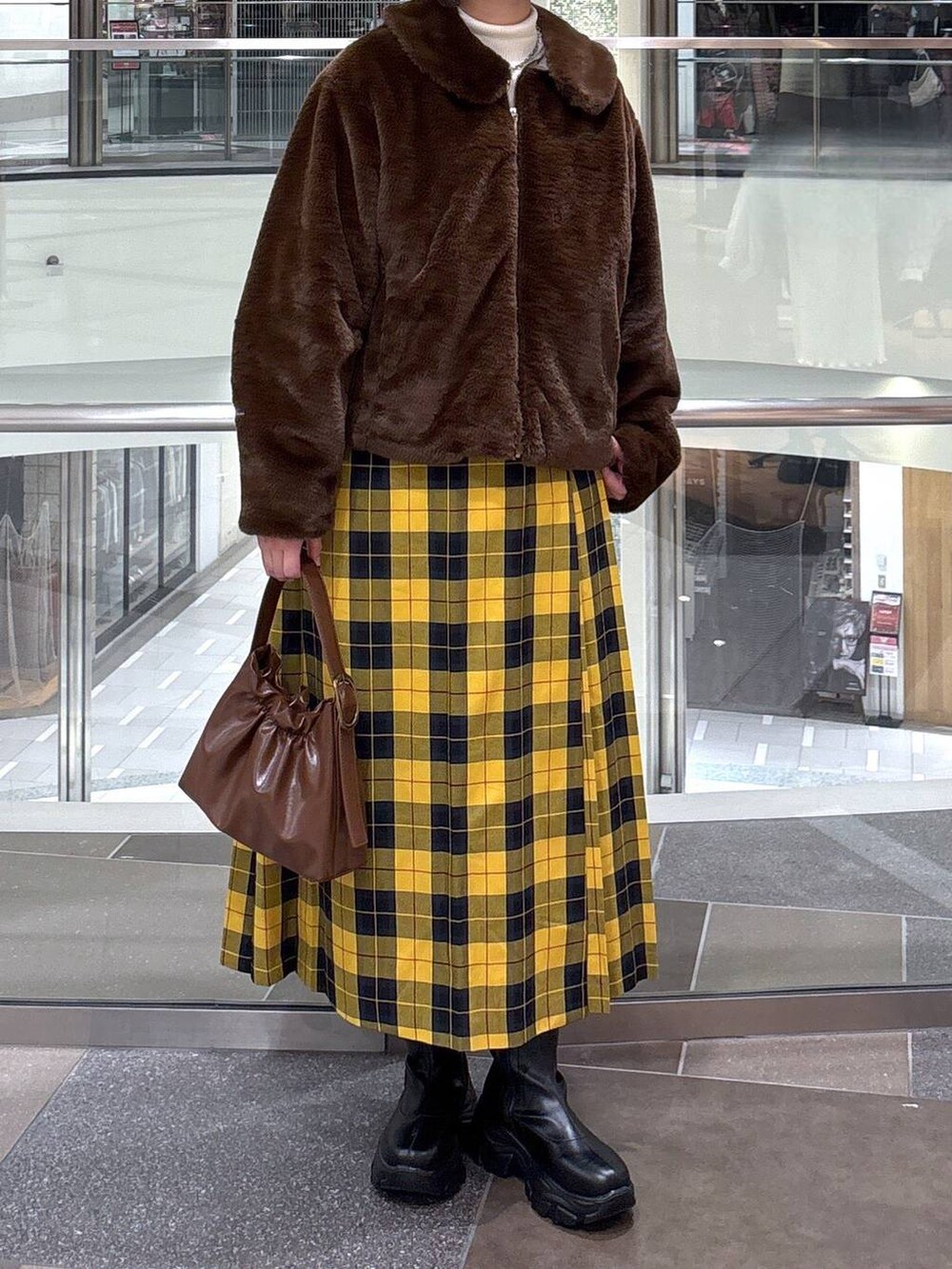 ブラック系のブーツ、ホワイト系のニット/セーター、ブラウン系のブルゾンを着用したレディースの冬コーディネートの3枚目の写真