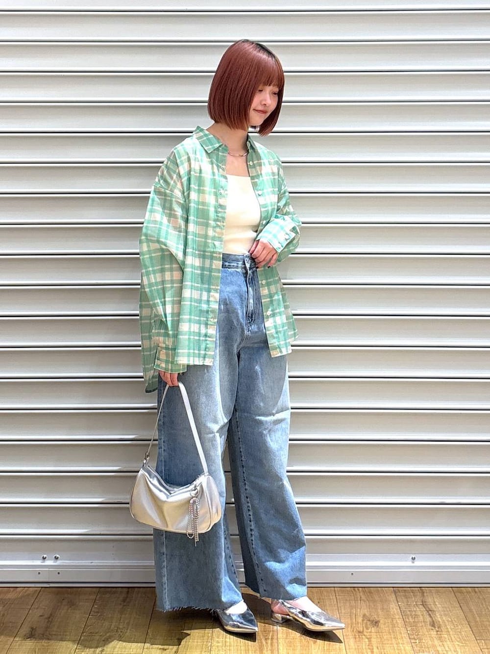 グリーン系のシャツ/ブラウス、シルバー系のトートバッグ、ホワイト系のタンクトップを着用したレディースの春コーディネートの2枚目の写真