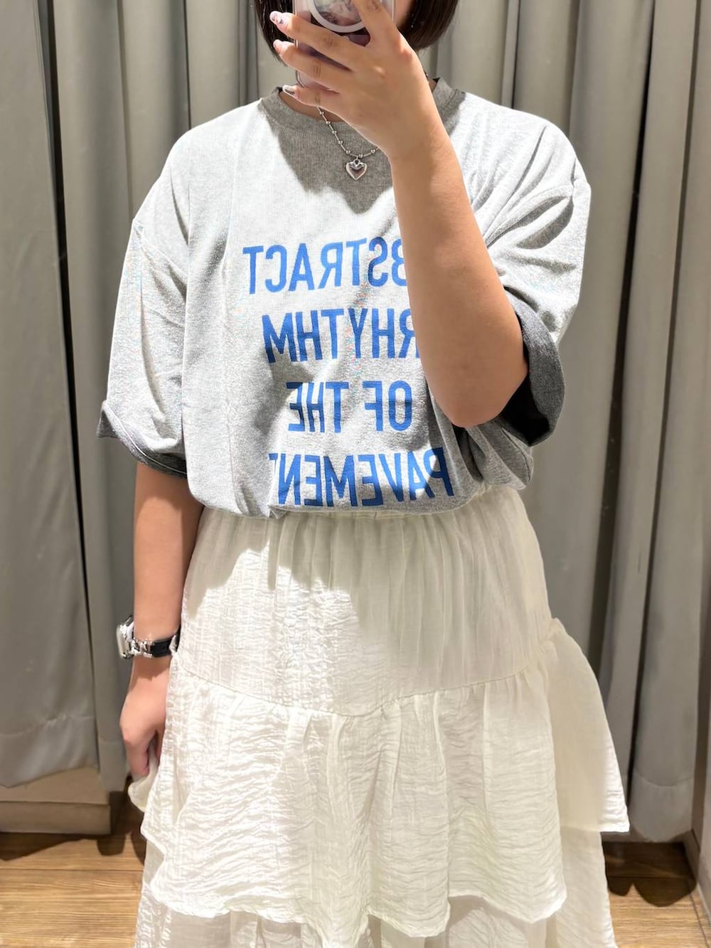 グレー系のTシャツ/カットソー、ホワイト系のスカートを着用したレディースの夏コーディネートの2枚目の写真