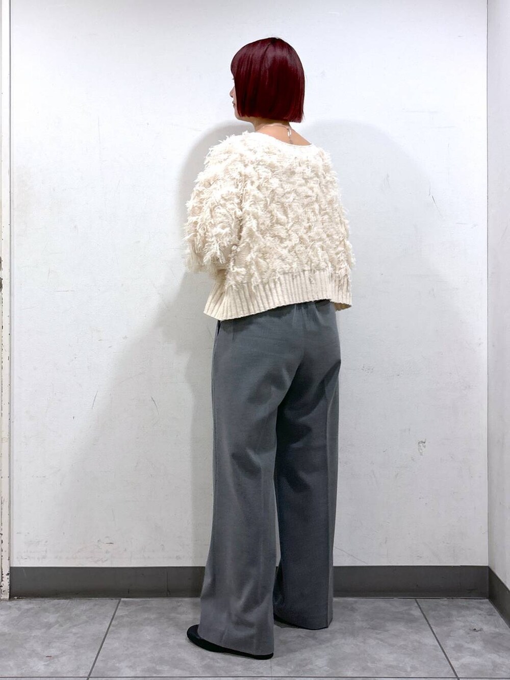 ブラック系のブーツ、グレー系のその他パンツ、ブラック系のハンドバッグを着用したレディースの秋コーディネートの3枚目の写真