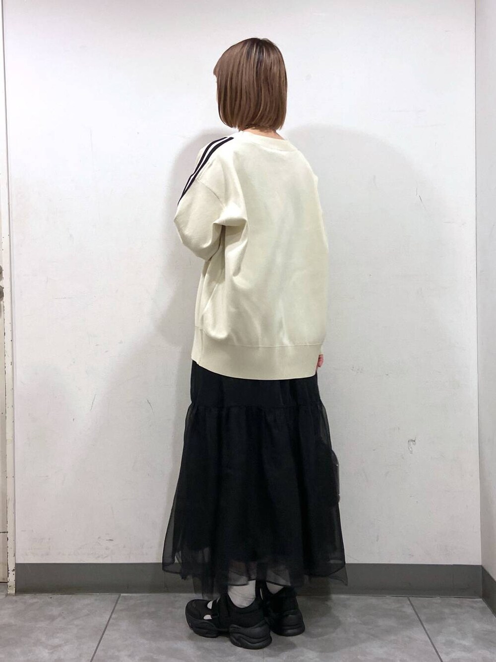 ブラック系のサンダル、ブラック系のショルダーバッグ、ホワイト系のカーディガン/ボレロを着用したレディースの春コーディネートの3枚目の写真