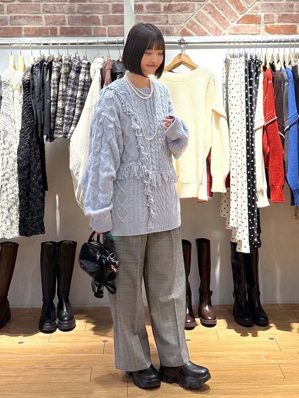 ブラック系のブーツ、その他のその他パンツ、ブラウン系のボストンバッグを着用したレディースの冬コーディネートの2枚目の写真