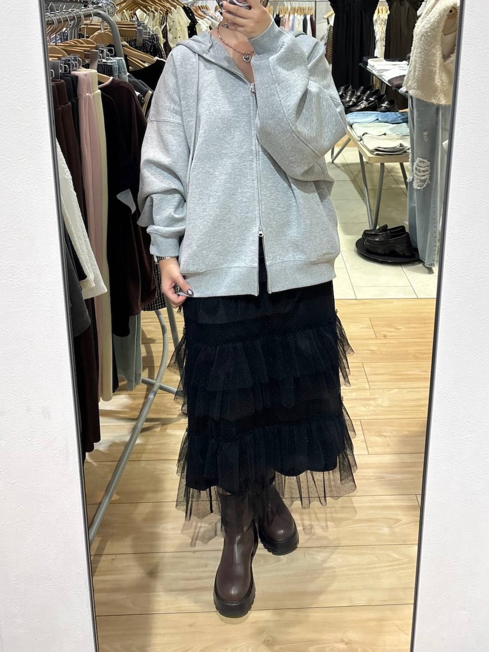 ブラック系のスカート、グレー系のパーカーを着用したレディースの秋コーディネートの3枚目の写真