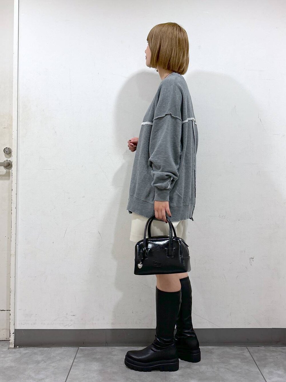 ブラック系のブーツ、ホワイト系のその他パンツ、グレー系のスウェットを着用したレディースの秋コーディネートの2枚目の写真