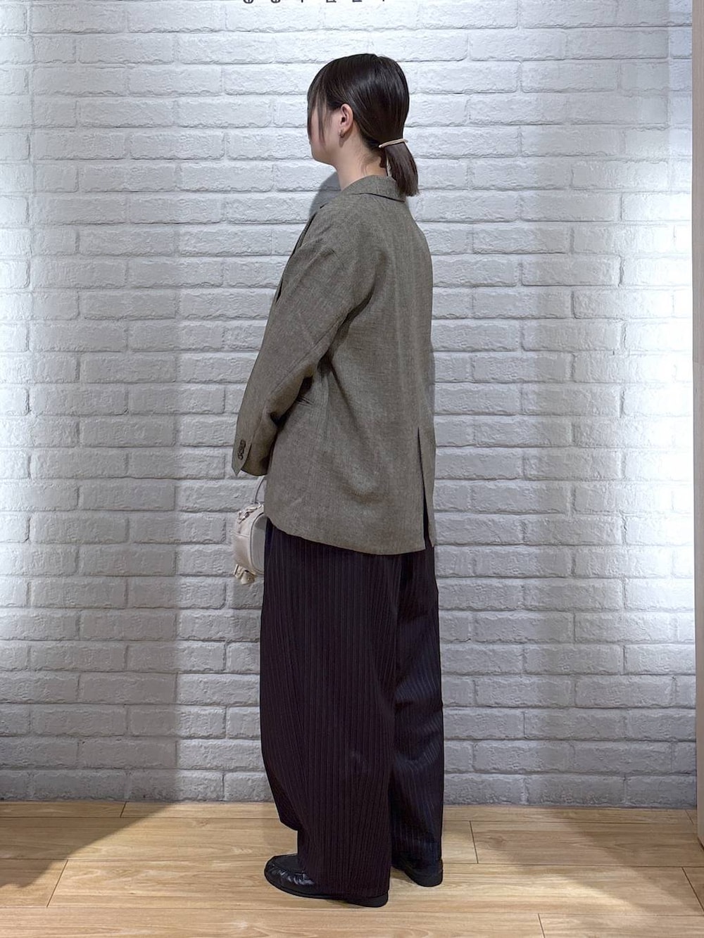 ブラウン系のその他パンツ、ブラウン系のテーラードジャケット、ホワイト系のボストンバッグを着用したレディースの春コーディネートの3枚目の写真