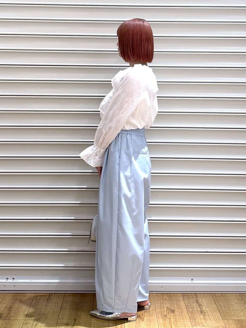 シルバー系のトートバッグ、シルバー系のパンプス、ホワイト系のシャツ/ブラウスを着用したレディースの春コーディネートの3枚目の写真
