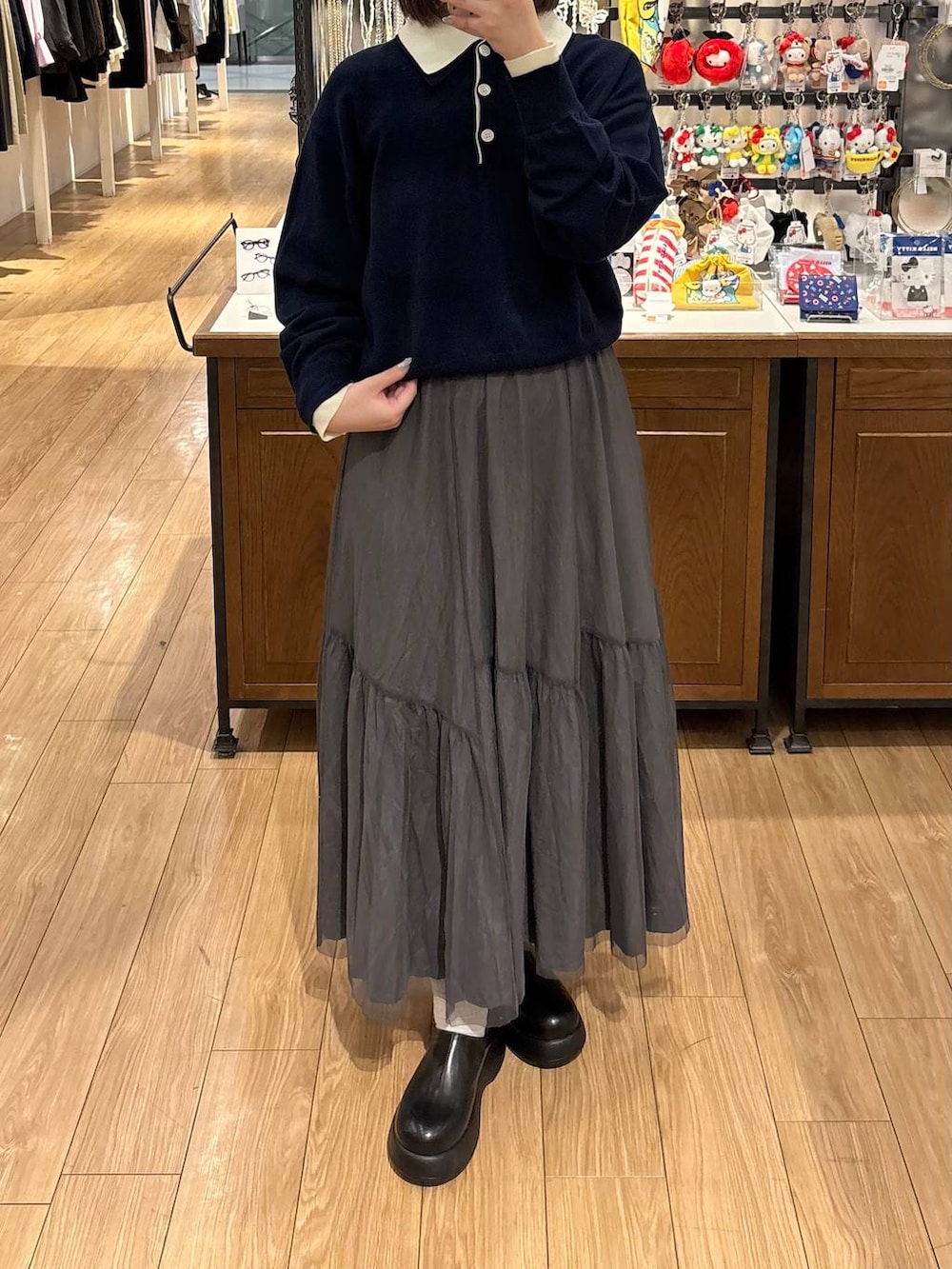 ブラック系のサンダル、グレー系のスカート、ブルー系のニット/セーターを着用したレディースの春コーディネートの3枚目の写真