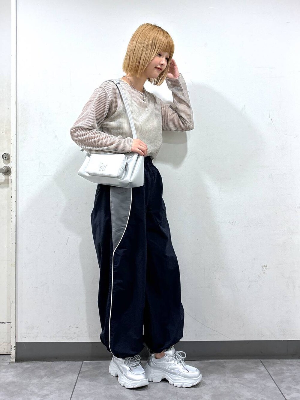 ブルー系のカーゴパンツ、シルバー系のショルダーバッグ、ホワイト系のタンクトップを着用したレディースの夏コーディネートの2枚目の写真