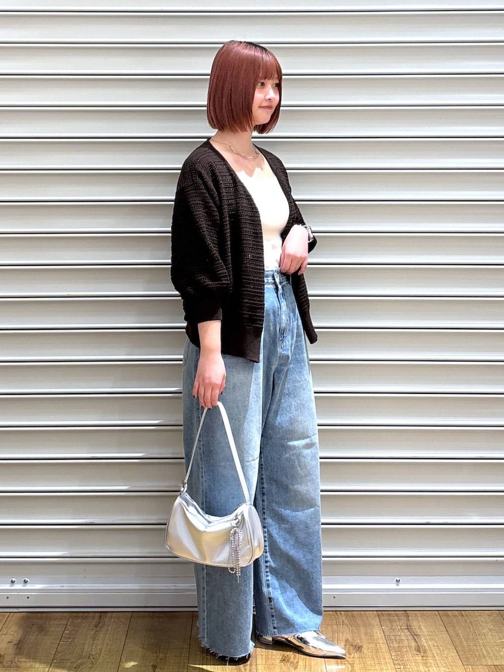 シルバー系のトートバッグ、シルバー系のパンプス、ホワイト系のタンクトップを着用したレディースの春コーディネートの2枚目の写真