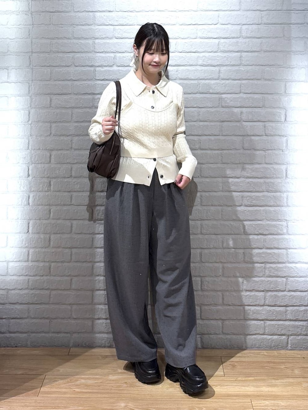 ブラウン系のボストンバッグ、グレー系のその他パンツ、ブラック系のローファーを着用したレディースの秋コーディネートの2枚目の写真
