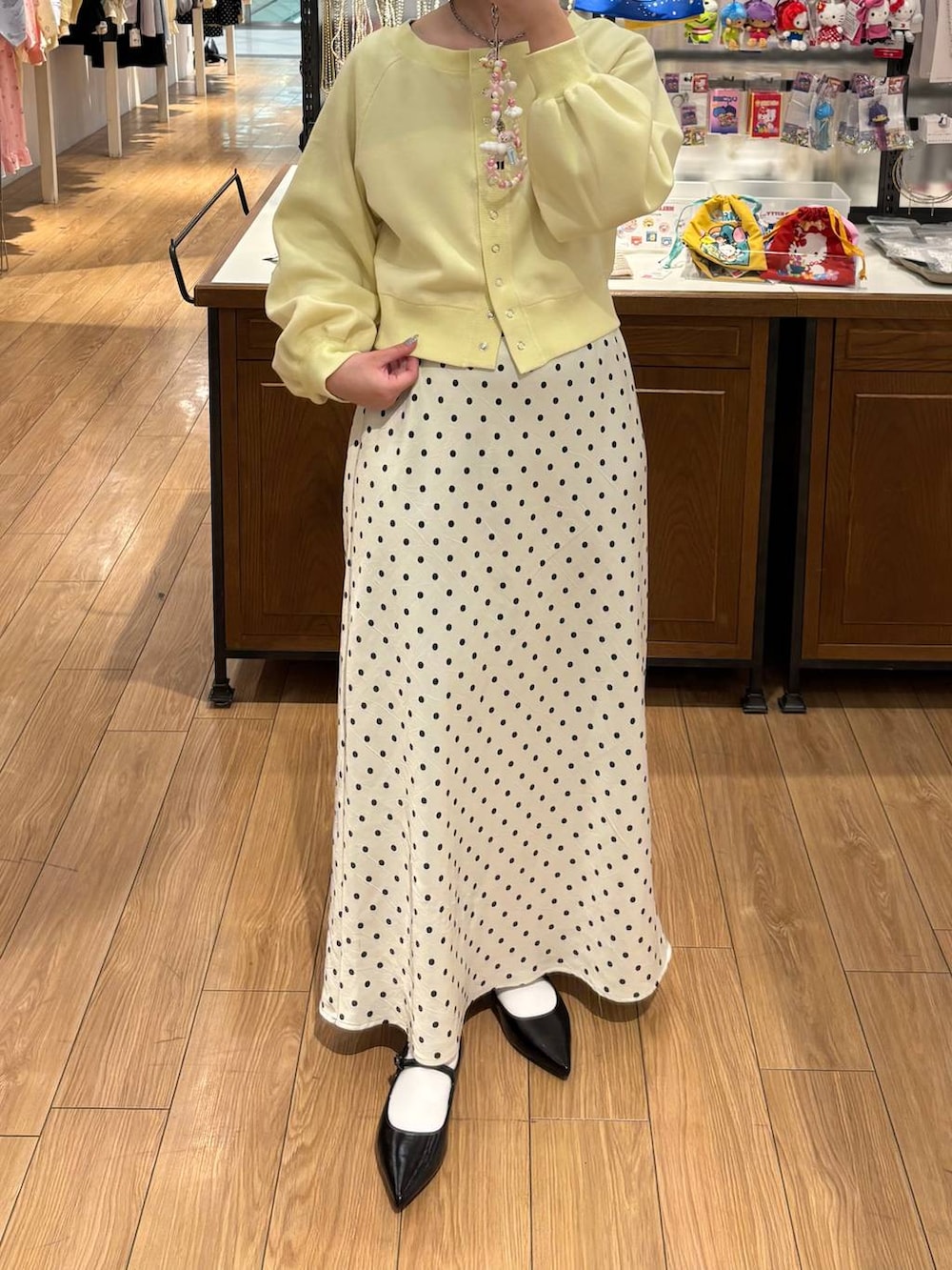 ホワイト系のスカート、ブラック系のパンプス、イエロー系のスウェットを着用したレディースの冬コーディネートの3枚目の写真