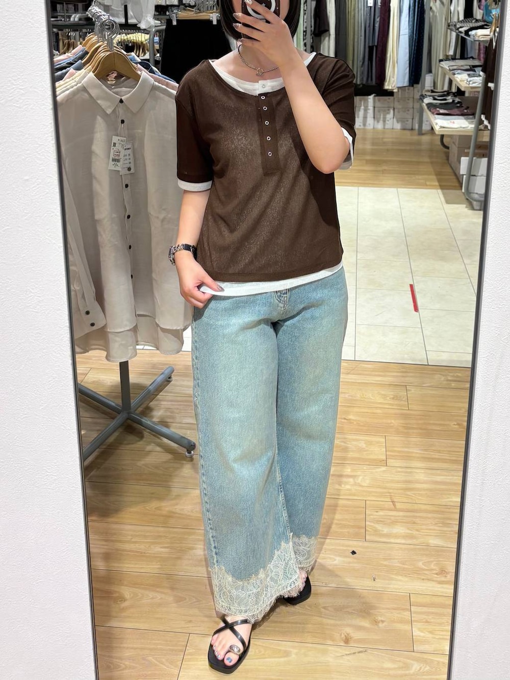 ブルー系のデニムパンツ、ブラック系のサンダル、ブラウン系のTシャツ/カットソーを着用したレディースの夏コーディネートの3枚目の写真