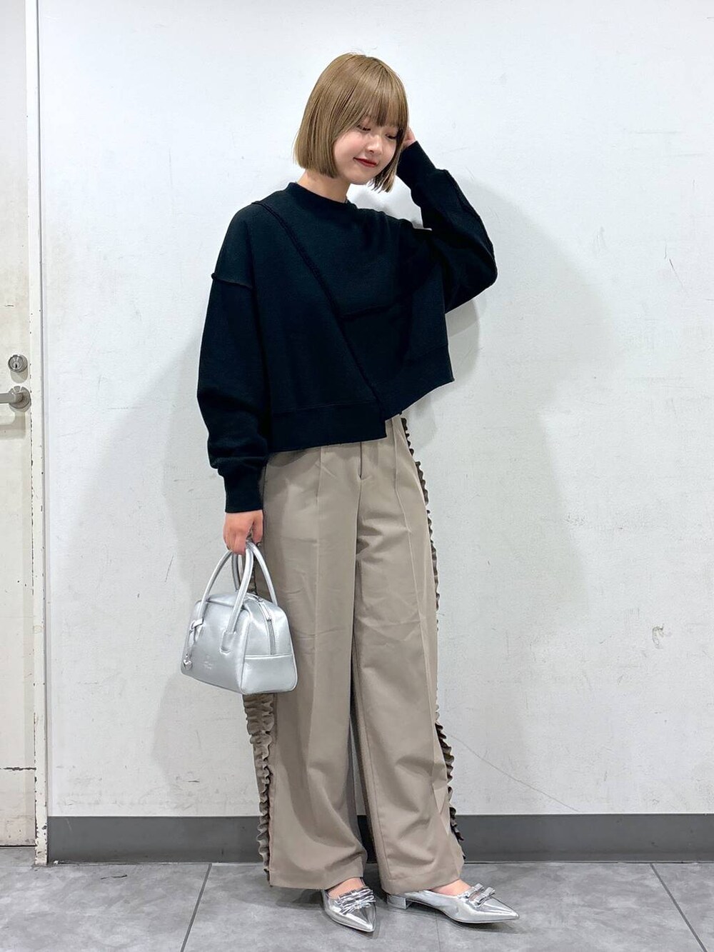 シルバー系のパンプス、シルバー系のボストンバッグ、グレー系のスウェットを着用したレディースの秋コーディネートの2枚目の写真