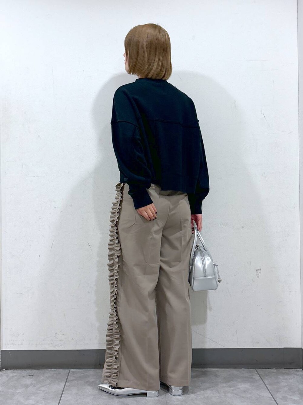 シルバー系のパンプス、シルバー系のボストンバッグ、グレー系のスウェットを着用したレディースの秋コーディネートの3枚目の写真