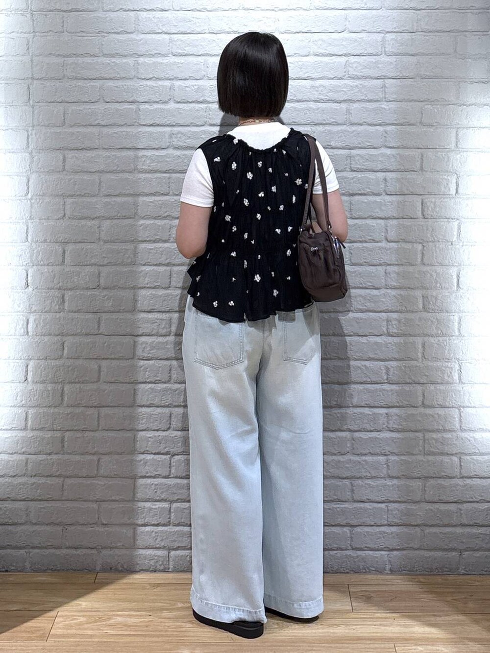 ホワイト系のTシャツ/カットソー、ブルー系のデニムパンツ、ブラウン系のサンダルを着用したレディースの夏コーディネートの3枚目の写真