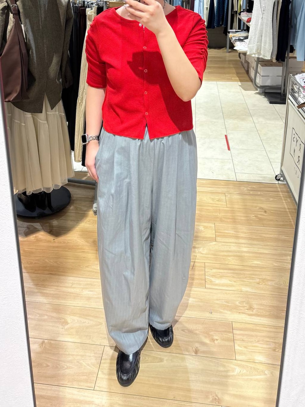 グレー系のその他パンツ、ブラック系のローファー、レッド系のTシャツ/カットソーを着用したレディースの春コーディネートの3枚目の写真