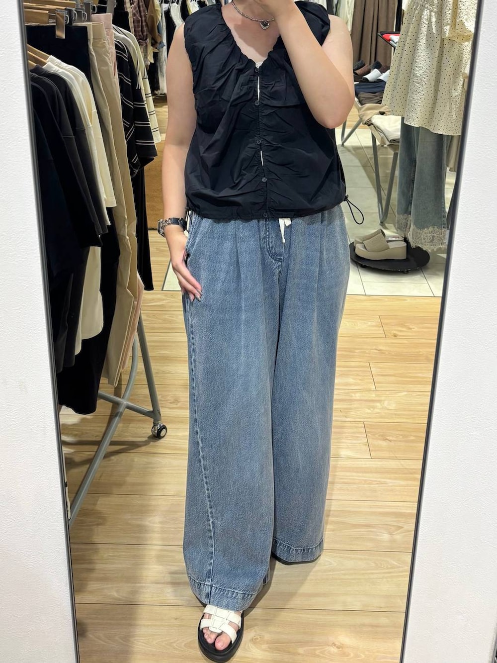 ブラック系のシャツ/ブラウス、ブルー系のデニムパンツ、ホワイト系のサンダルを着用したレディースの夏コーディネートの3枚目の写真