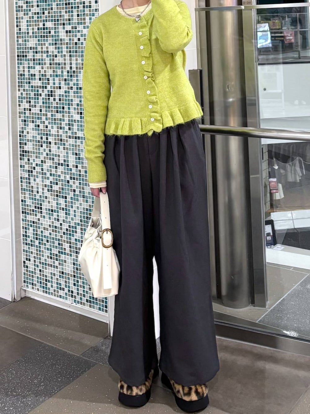 その他のサンダル、グレー系のその他パンツ、イエロー系のニット/セーターを着用したレディースの冬コーディネートの3枚目の写真