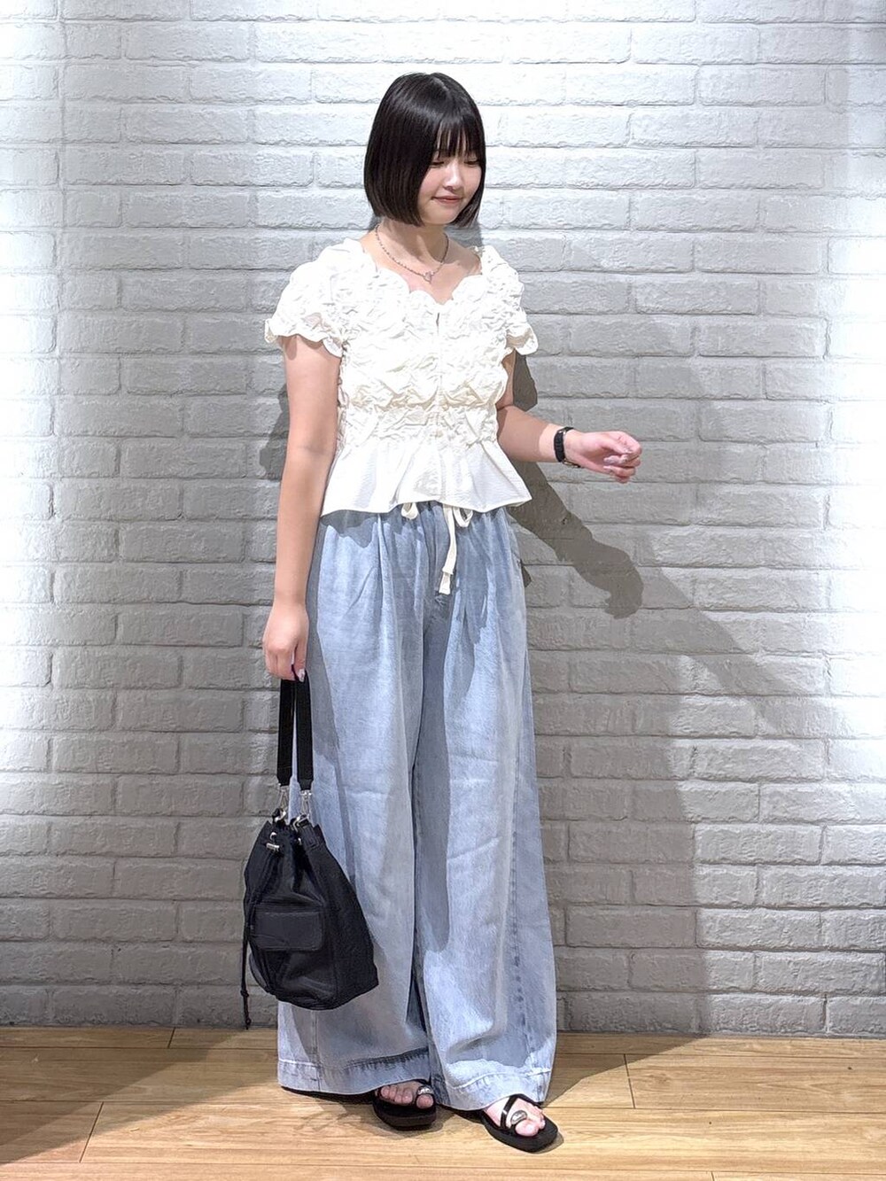 ホワイト系のシャツ/ブラウス、ブルー系のデニムパンツ、ブラック系のサンダルを着用したレディースの夏コーディネートの2枚目の写真