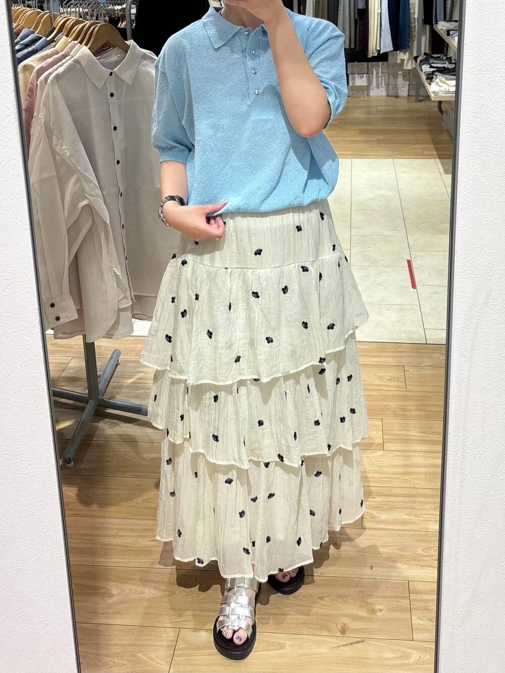 シルバー系のサンダル、ブルー系のTシャツ/カットソー、ホワイト系のスカートを着用したレディースの夏コーディネートの3枚目の写真