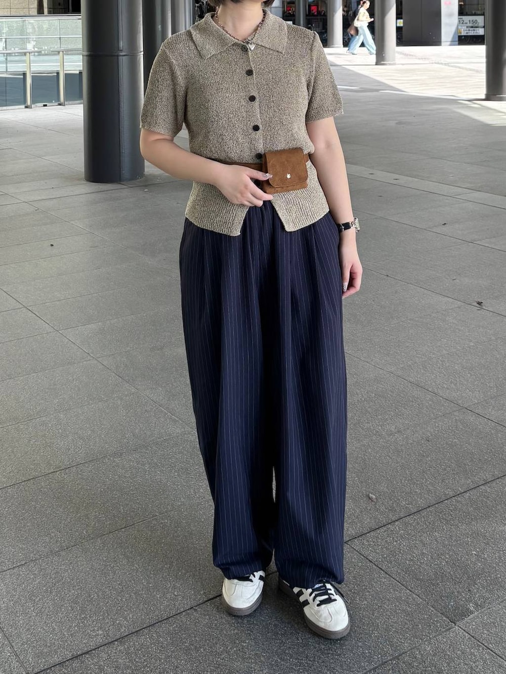 ブルー系のその他パンツ、ベージュ系のTシャツ/カットソー、イエロー系のベルトを着用したレディースの春コーディネートの3枚目の写真